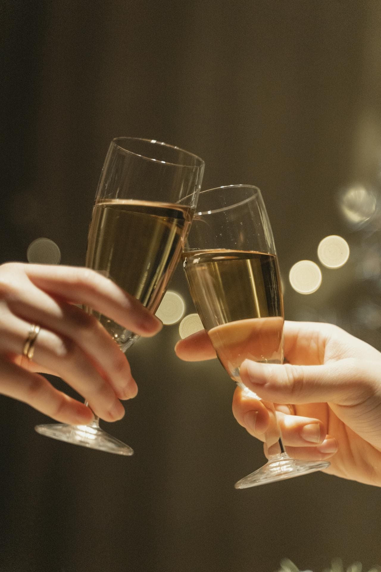 Close-up shot of hands having a toast using a glass of champagne