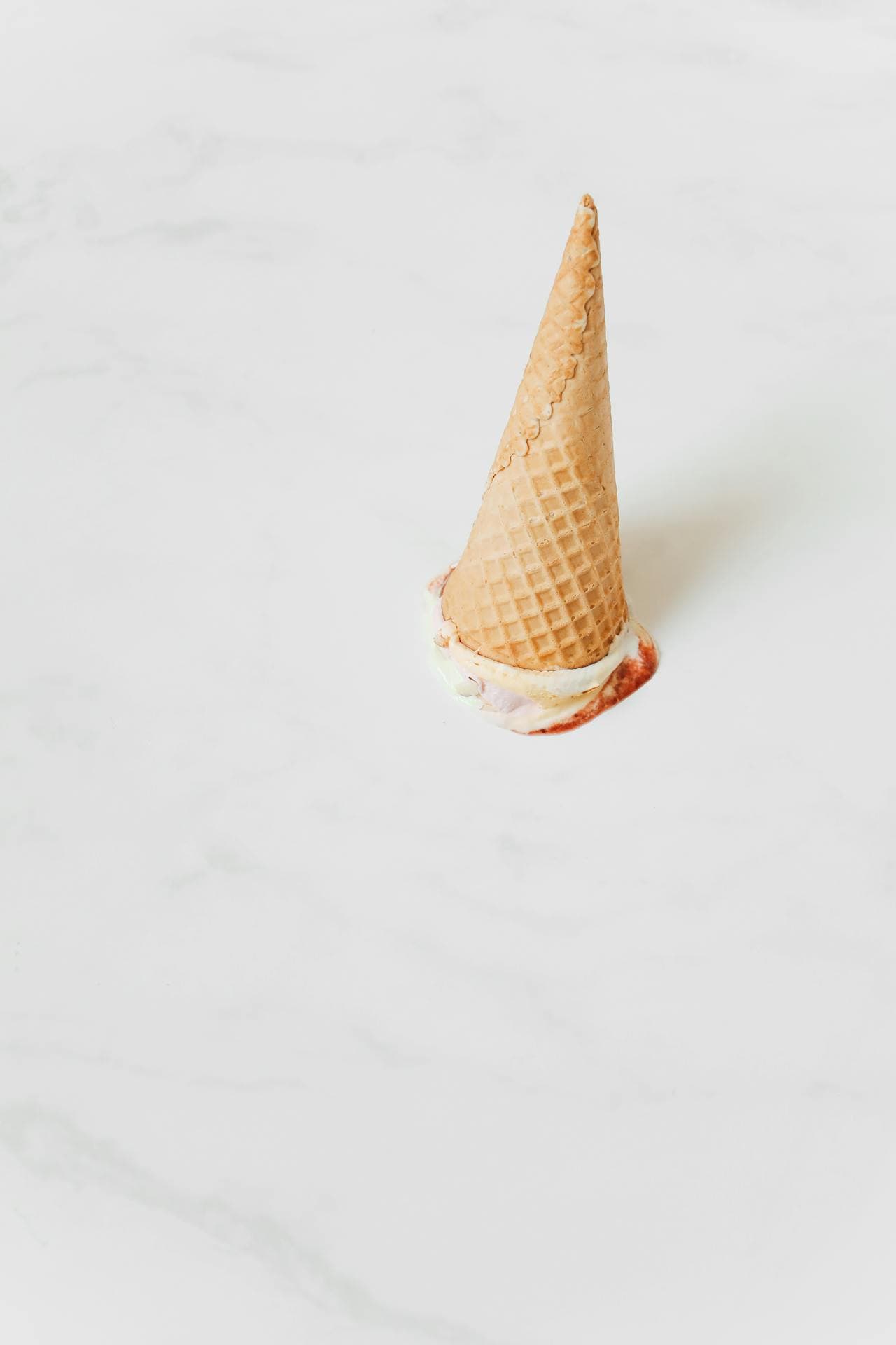 Dropped ice cream cone on white background