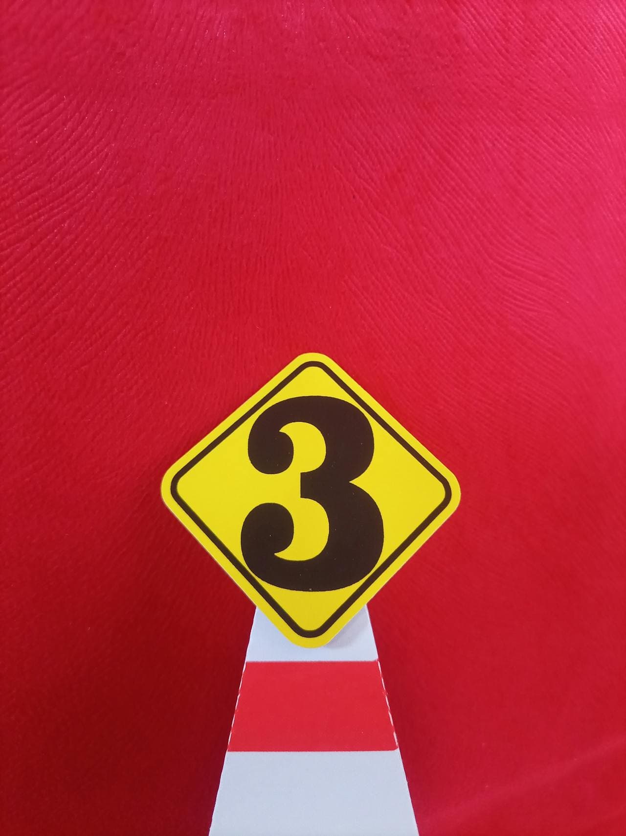 Yellow diamond sign with number 3 on red background